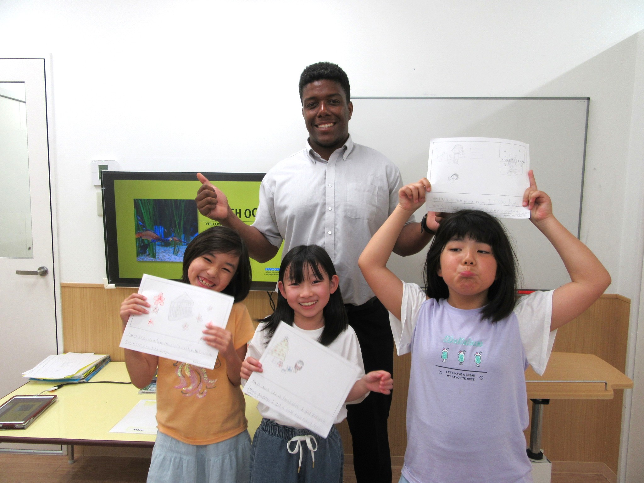 イーオンキッズ一宮校　小学校３・４年生クラスの生徒様とダラス先生。皆で仲良くレッスンを受けています。