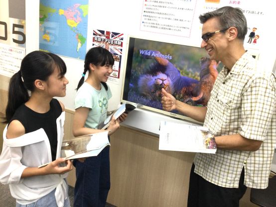 海外の写真がたくさん印刷されたテキストを使います。音源はアプリでいつでも聴けます！