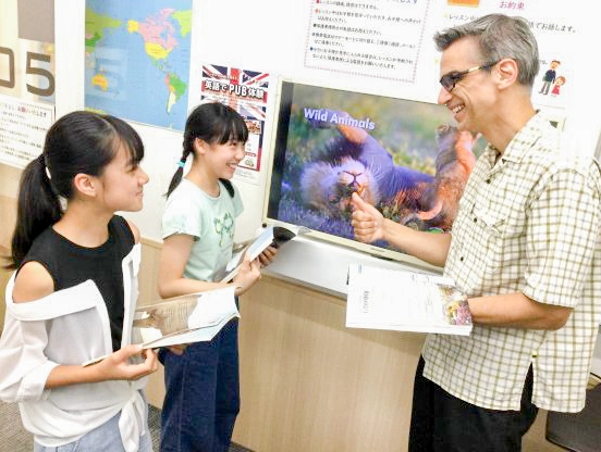 海外の写真がたくさん印刷されたテキストを使います。音源はアプリでいつでも聴けます！