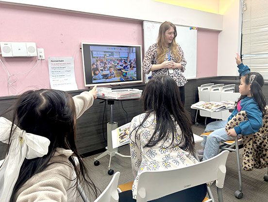 小学生の生徒様が楽しくグループレッスンをうけています、外国人教師